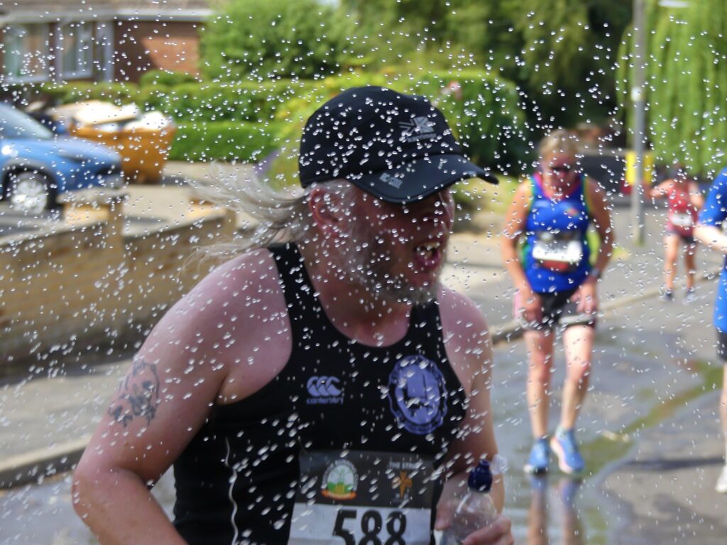 Runner getting a watering on the 10k course